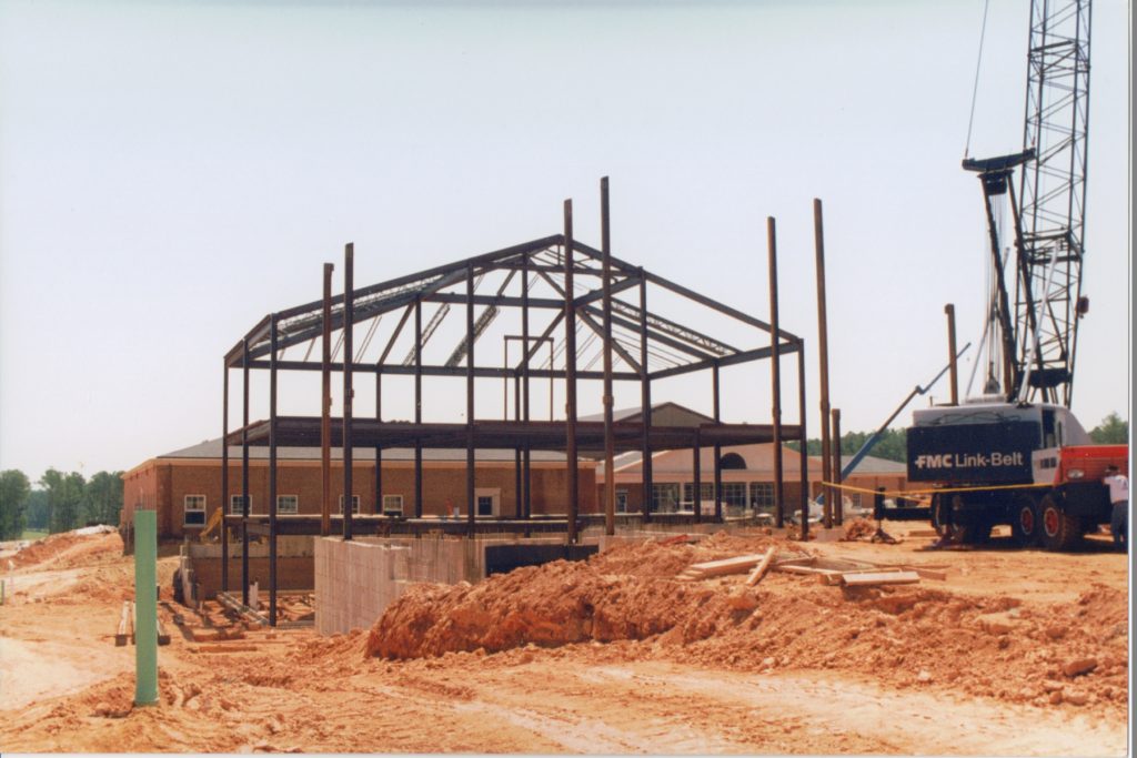 A crane raises the structural steel for Berger Hall while Cary Academy's campus is under construction.